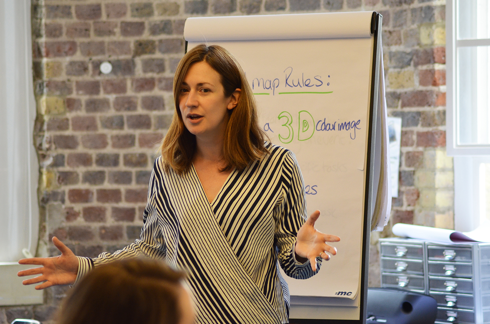 Laura Slater, =mc Director standing in front of a flip chart while delivering training.